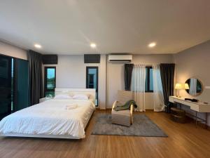 1 dormitorio con 1 cama blanca grande y 1 silla en Cheri’s homestay现代两层独栋别墅，4卧4卫，3日送接机1周接送机,近Mega邦纳, en Bangkok