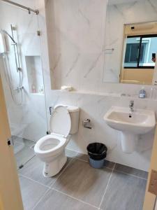a white bathroom with a toilet and a sink at Cheri’s homestay现代两层独栋别墅，4卧4卫，3日送接机1周接送机,近Mega邦纳 in Bangkok