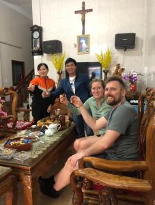 grupa ludzi siedzących przy stole w obiekcie Phong Nha Backpacker Hostel w mieście Cừ Lạc