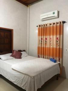 sypialnia z łóżkiem z pomarańczową zasłoną w obiekcie Phong Nha Backpacker Hostel w mieście Cừ Lạc