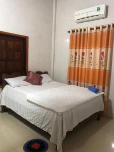 a bedroom with a bed with an orange curtain at Phong Nha Backpacker Hostel in Cừ Lạc