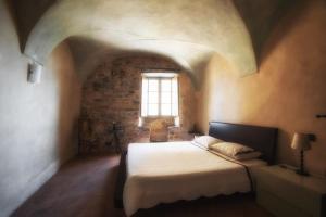 een slaapkamer met een bed in een kamer met een raam bij Ca' del Vescovo in Costarainera