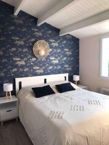 um quarto com uma cama grande e papel de parede floral azul em Maison rénovée - draps inclus - 700m plage em Barbâtre