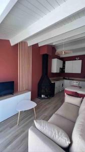 uma sala de estar com um sofá e uma lareira em Maison rénovée - draps inclus - 700m plage em Barbâtre