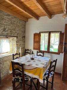 ein Esszimmer mit einem Tisch mit Stühlen und einer Steinmauer in der Unterkunft Casa Fortuna in Armiello