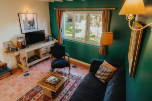 een woonkamer met een bank en een tv bij La Casita in Cheilly-lès-Maranges