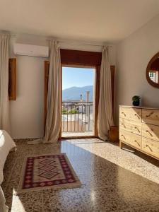 a bedroom with a bed and a large sliding glass door at Peaceful Townhouse Retreat in Órgiva