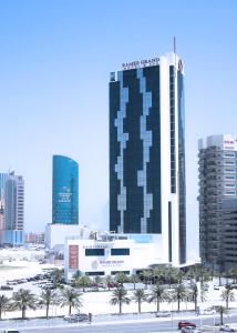 a tall building in the middle of a city at Ramee Grand Hotel And Spa in Manama