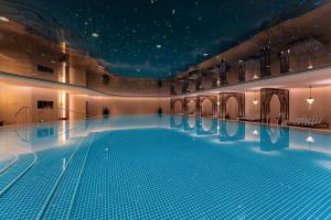 a large swimming pool with blue water in a building at The Langbo Chengdu, in The Unbound Collection by Hyatt in Chengdu