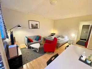 sala de estar con cama y silla roja en Whole Apartment 20 minutes from the city center, en Søborg