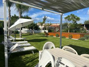 a patio with a table and chairs and an umbrella at Home Olympus Vesuvio in Pompei