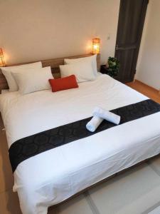 a large white bed with a towel on it at Nestle Inn Hakuba in Hakuba +1 photo