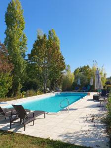 uma piscina com duas cadeiras e um guarda-sol em Lemoniegites em Lemonie