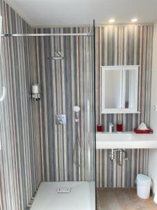 a bathroom with a shower and a sink and a mirror at Casa S’Arraval in Mahón