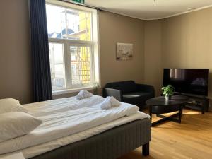 a bedroom with a bed and a chair and a window at Vestre Torggaten 20 in Bergen