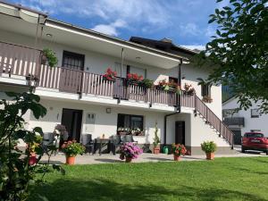 a white building with a balcony with flowers on it at APARTMA PANORAMA in Kobarid