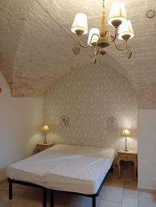 1 Schlafzimmer mit einem weißen Bett und 2 Nachttischen in der Unterkunft Appartamento la Birba in Alberobello