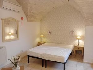ein Schlafzimmer mit einem Bett und zwei Tischen mit Lampen in der Unterkunft Appartamento la Birba in Alberobello