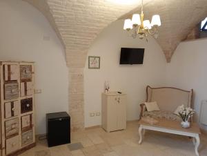 a living room with a couch and a tv on the wall at trullo la birba in Alberobello