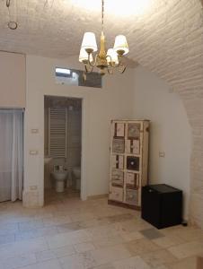 ein Bad mit einem WC und einem Kronleuchter in der Unterkunft Appartamento la Birba in Alberobello