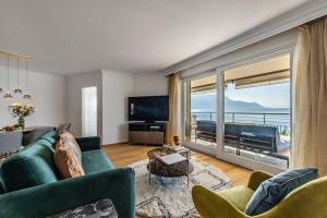 een woonkamer met een groene bank en een groot raam bij Lake View Montreux Jazz Festival in Montreux