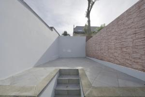 un escalier menant à un mur de briques dans l'établissement Studio Didine, à Charleroi