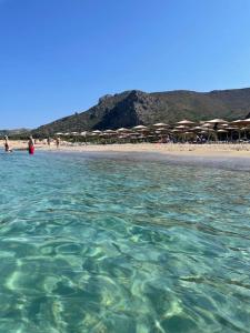a body of water with a beach with umbrellas at Appartement Chania Centrum in Chania Town