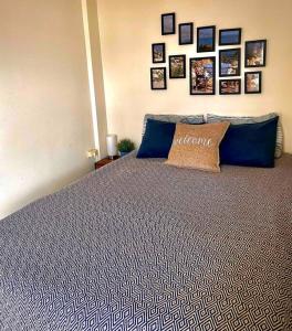 1 dormitorio con 1 cama con almohadas azules y cuadros en la pared en Appartement Chania Centrum en La Canea