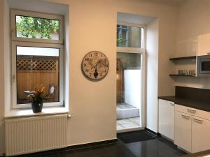 une cuisine avec une horloge sur le mur à côté d'une fenêtre dans l'établissement Apartment with living room, 2 bedrooms, balcony, à Vienne