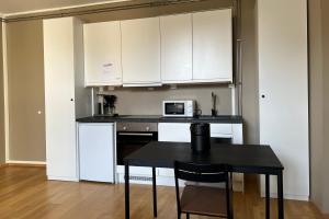 a kitchen with white cabinets and a table with a microwave at Vestre Torggaten 20 in Bergen