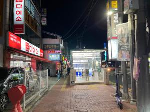 a city street at night with people walking down the street at The house of gallery in Daegu