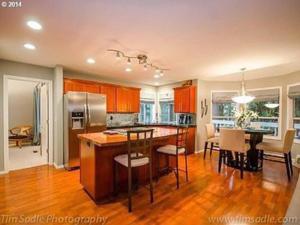 a kitchen with a island and a table in it at Forest & City Views - Near Portland, Nike & Intel in Beaverton