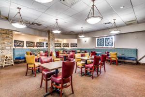 um restaurante com mesas e cadeiras num quarto em Wyndham Garden Wichita Downtown em Wichita