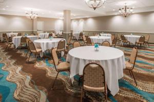 una sala de conferencias con mesas, sillas y lámparas de araña en Wyndham Garden Wichita Downtown, en Wichita