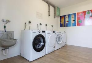 a laundry room with two washing machines and a sink at B - HOME Apartments in Koblenz