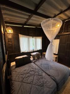 Schlafzimmer mit einem Bett mit Moskitonetz in der Unterkunft The Legend Homestay. in Mae Ai Chiang Mai