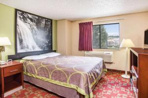 a hotel room with a bed and a window at Super 8 by Wyndham Harrisonburg in Harrisonburg