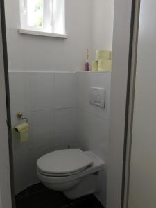 La salle de bains blanche est pourvue de toilettes et d'une fenêtre. dans l'établissement Apartment with living room, 2 bedrooms, balcony, à Vienne