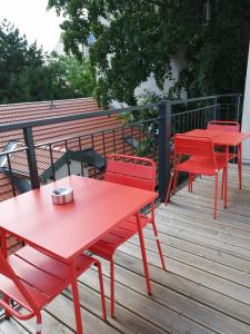 deux tables et chaises rouges sur une terrasse dans l'établissement Apartment with living room, 2 bedrooms, balcony, à Vienne