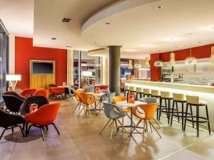 a restaurant with chairs and tables and a bar at Novotel Berlin Mitte in Berlin