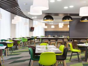 un comedor con mesas y sillas verdes en Novotel St Petersburg Centre en San Petersburgo