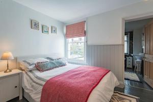 a bedroom with a large bed and a window at SeaFern Cottage in Whitstable