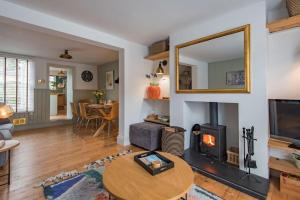 a living room with a fireplace and a table at SeaFern Cottage in Whitstable