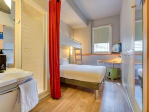 een slaapkamer met een bed en een badkamer met een wastafel bij ibis budget Hotel Luzern City in Luzern