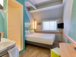 een kleine kamer met een bed en een wastafel bij ibis budget Hotel Luzern City in Luzern