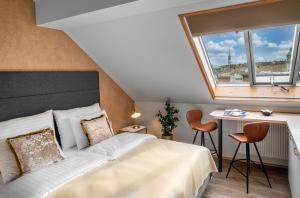 a bedroom with a bed and a desk and a window at Theatre 9 Apartments by Adrez in Prague