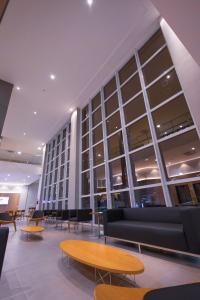- un hall d'un immeuble avec des tables et des chaises dans l'établissement Hotel Caiuá Blumenau, à Blumenau