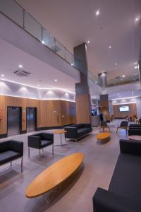 a lobby with couches and tables in a building at Hotel Caiuá Blumenau in Blumenau