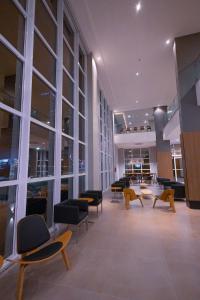 un hall avec des chaises et des tables dans un bâtiment dans l'établissement Hotel Caiuá Blumenau, à Blumenau