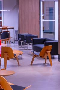 um quarto com cadeiras, mesas e mesas em Hotel Caiuá Blumenau em Blumenau